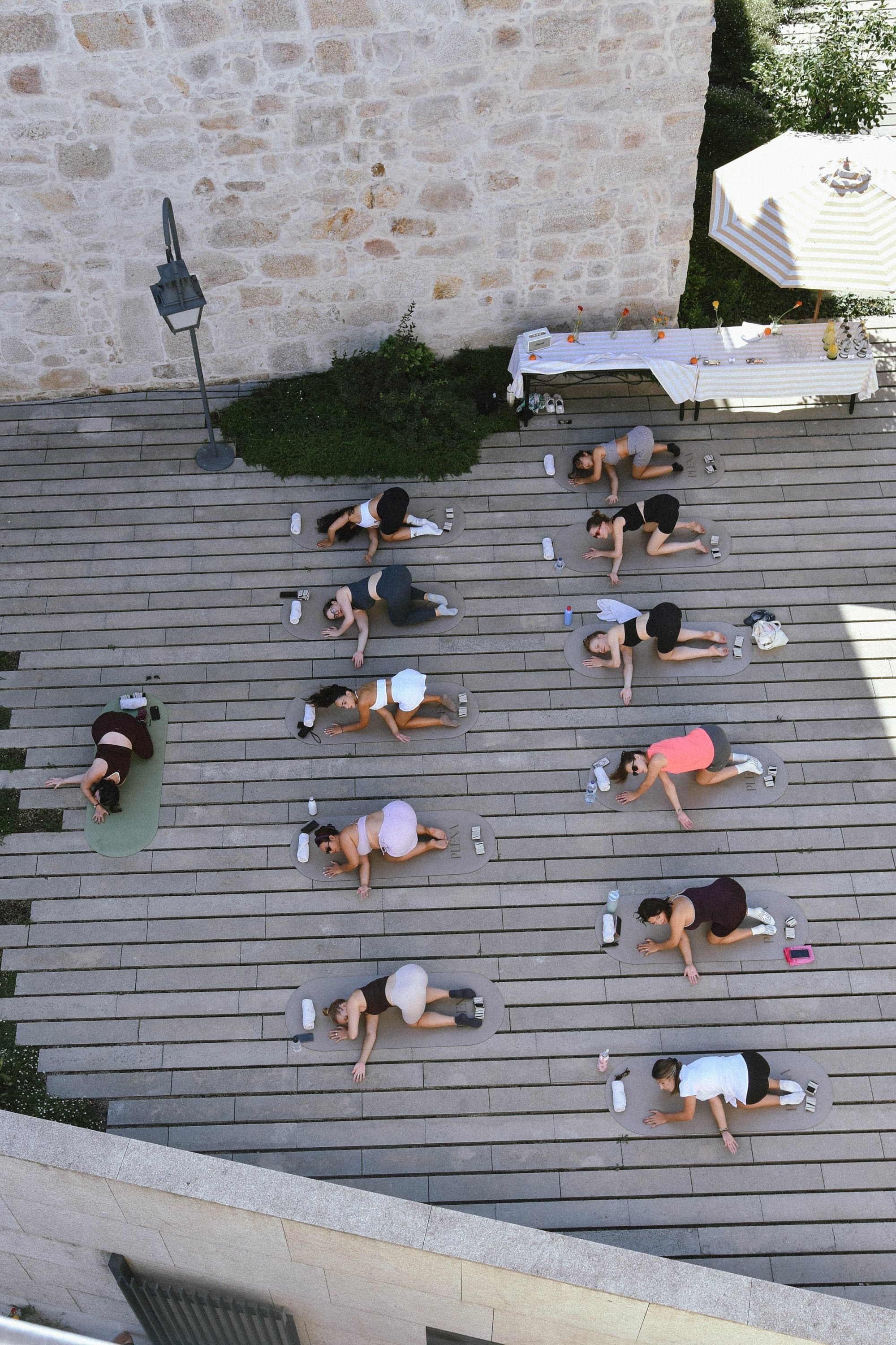 The sculpt class seen from above, on mats across a wooden deck.