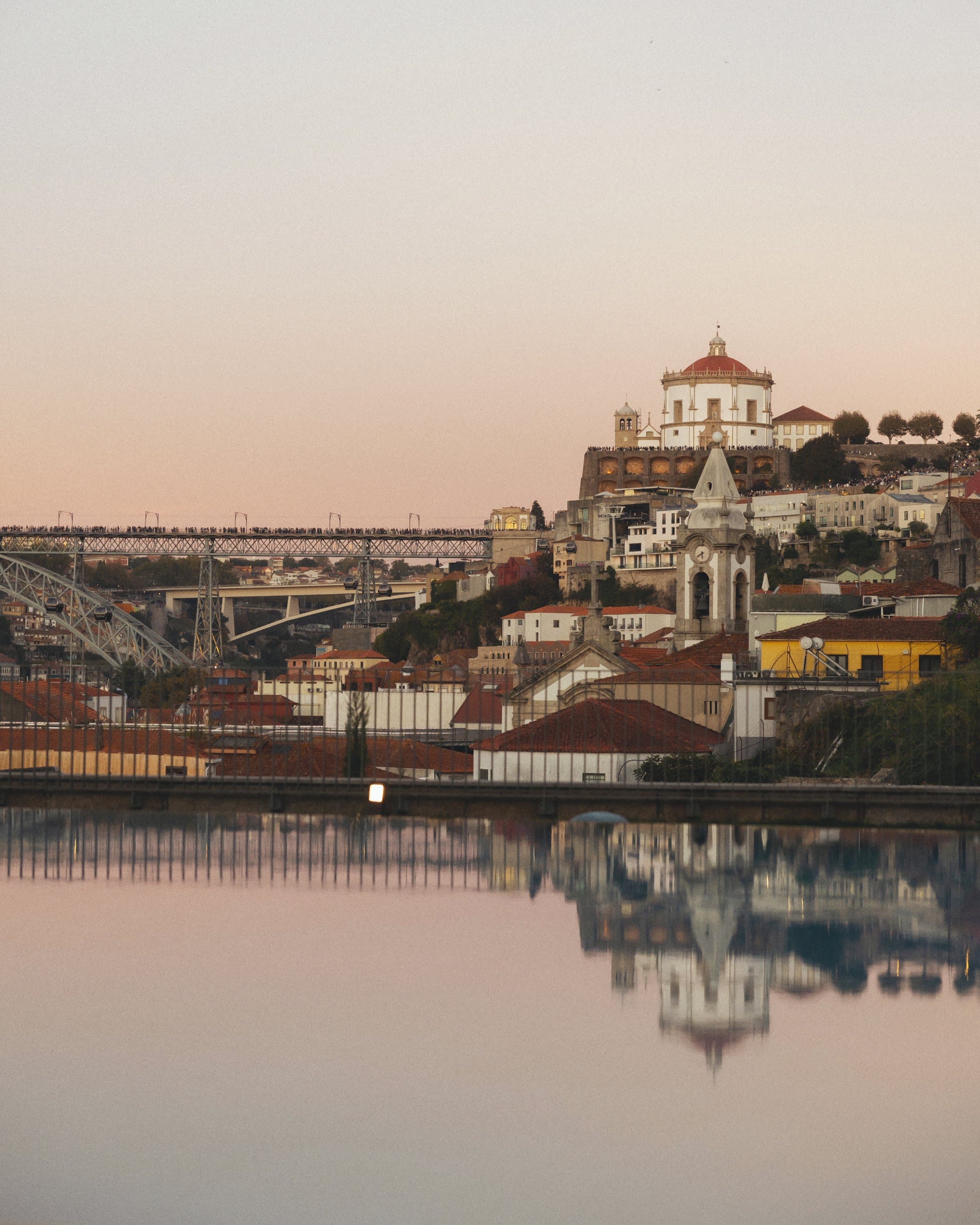 An infinity pool reflects Porto at dusk.